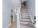 Bright entryway featuring light wood stairs, soft blue walls, and a hallway leading to the kitchen and living areas at 7636 Heritage Crossing Way, Reunion, FL 34747
