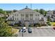 Well-maintained, three-story building with a light gray and white paint scheme and a columned entrance and manicured landscaping at 7636 Heritage Crossing Way, Reunion, FL 34747