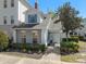 Charming two-story home featuring manicured landscaping, a brick chimney, and a welcoming front entrance at 7636 Heritage Crossing Way, Reunion, FL 34747
