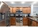 Well-equipped kitchen with stainless steel appliances, granite countertops, and wood cabinetry for ample storage at 7636 Heritage Crossing Way, Reunion, FL 34747