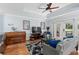 Comfortable living room with hardwood floors, ceiling fan, piano, and sliding doors to the outside at 7636 Heritage Crossing Way, Reunion, FL 34747
