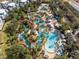 Stunning aerial view of a waterpark with winding pools, lush landscaping, and colorful seating areas at 7636 Heritage Crossing Way, Reunion, FL 34747
