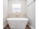 Elegant bathroom featuring a modern soaking tub, sleek fixtures, and stylish wood-look flooring at 2155 Thompson Rd, Bartow, FL 33830