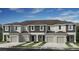 Attractive townhome featuring a gray and white facade, attached garages, and well-maintained landscaping at 2537 Penguin Blvd, Davenport, FL 33837