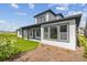 Exterior angle view of home featuring a covered patio, sleek lines, and landscaping at 6615 Quest St, St Cloud, FL 34771