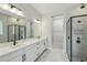 Modern bathroom featuring double vanity, large mirror, and glass shower with tile surround at 6615 Quest St, St Cloud, FL 34771