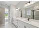 Modern bathroom features a double vanity, large mirror, and a glass-enclosed shower for a sleek and functional design at 6615 Quest St, St Cloud, FL 34771
