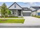 Charming home with gray trim, stone accents, a well-manicured lawn, and an attached two-car garage at 6615 Quest St, St Cloud, FL 34771