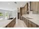A kitchen is featuring custom cabinets, stainless appliances, and a large island with quartz countertop and tile backsplash at 6615 Quest St, St Cloud, FL 34771