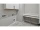 Functional laundry room features gray tile and built-in counter for folding at 6615 Quest St, St Cloud, FL 34771