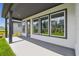 Covered patio featuring large windows, concrete flooring, and views of the landscaped backyard at 6615 Quest St, St Cloud, FL 34771