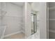 Open walk-in closet provides ample storage and shelving leading to a modern bathroom with a glass enclosed shower at 6615 Quest St, St Cloud, FL 34771