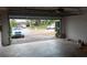 A view from the garage looking outside, revealing a quiet, tree-lined street at 5118 Log Wagon Rd, Ocoee, FL 34761