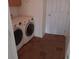 Well-lit laundry room with a side-by-side washer and dryer setup and tile flooring at 5118 Log Wagon Rd, Ocoee, FL 34761