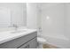 Bright bathroom featuring a gray vanity, sleek faucet, and a tiled shower-over-tub combination at 5774 Greenery Ln, St Cloud, FL 34771