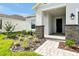 Inviting front entrance with stone pillars, manicured landscaping, and a paved walkway to the front door at 5774 Greenery Ln, St Cloud, FL 34771