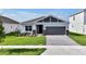 Charming single-story home with a well-manicured lawn, gray brick accents, and a spacious driveway at 5774 Greenery Ln, St Cloud, FL 34771