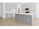 Stylish kitchen featuring a large island, gray cabinets, quartz countertops, and stainless steel appliances at 5774 Greenery Ln, St Cloud, FL 34771