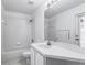 All-white bathroom with tub and shower combination, sink, and door to backyard at 1372 Madison Ivy Cir, Apopka, FL 32712