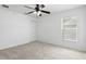 A carpeted bedroom features a ceiling fan, large window, and closet at 1372 Madison Ivy Cir, Apopka, FL 32712