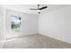 A carpeted bedroom with a ceiling fan and large window overlooking a water view at 1372 Madison Ivy Cir, Apopka, FL 32712