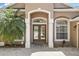 Elegant entryway with double doors, decorative columns, and brick pavers at 1372 Madison Ivy Cir, Apopka, FL 32712