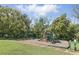 Community playground featuring swings, slides, and mature shade trees for Gathering fun and outdoor activities at 1372 Madison Ivy Cir, Apopka, FL 32712