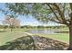 Beautiful view of the community pond, surrounded by a walking path and lush trees at 1372 Madison Ivy Cir, Apopka, FL 32712