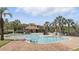 Community pool featuring brick surround, covered lounge, and mature landscaping, perfect for relaxation and recreation at 1372 Madison Ivy Cir, Apopka, FL 32712
