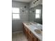 Bathroom featuring a wooden vanity with double sinks and a large mirror with overhead vanity lighting at 14417 Jasmine Glen Dr, Orlando, FL 32824