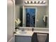 Bright bathroom with a white single sink vanity, mirror, and a view of the stairway to the next level at 14417 Jasmine Glen Dr, Orlando, FL 32824