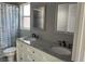 Bathroom with double sinks, granite countertop, large mirror, and decorative shower curtain at 14417 Jasmine Glen Dr, Orlando, FL 32824