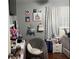 Bedroom featuring hardwood floors, an upholstered accent chair, and playful wall decor at 14417 Jasmine Glen Dr, Orlando, FL 32824