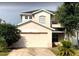 Two-story home featuring an attached two-car garage and mature landscaping at 14417 Jasmine Glen Dr, Orlando, FL 32824
