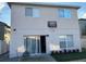 Back of home features a sliding glass door, a basketball hoop, and small landscaping at 14417 Jasmine Glen Dr, Orlando, FL 32824
