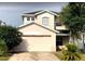 Two-story home with a two car garage, black roof, and well-maintained front yard at 14417 Jasmine Glen Dr, Orlando, FL 32824