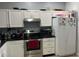 Functional kitchen layout with a stainless steel oven, black countertops and white cabinets at 14417 Jasmine Glen Dr, Orlando, FL 32824