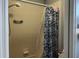 Bathroom featuring a shower with beige tile, an adjustable shower head, and a blue shower curtain at 14417 Jasmine Glen Dr, Orlando, FL 32824