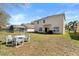 A backyard with a screened-in lanai and patio furniture, set in a grassy yard at 754 Andalusia Loop, Davenport, FL 33837