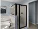 Close-up of a modern bathroom with glass shower enclosure, garden tub, and neutral tile at 754 Andalusia Loop, Davenport, FL 33837