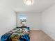 Simple bedroom with natural lighting, a twin bed with fun bedding, and neutral carpet at 754 Andalusia Loop, Davenport, FL 33837