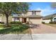 Charming two-story home featuring a well-manicured lawn, brick driveway, and a welcoming two-car garage at 754 Andalusia Loop, Davenport, FL 33837