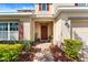 Inviting front porch adorned with vibrant plants, a decorative door, and colorful landscaping creating a welcoming entry at 754 Andalusia Loop, Davenport, FL 33837