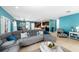Open-concept living area with stylish furniture, neutral tile flooring, flowing into dining and kitchen spaces at 754 Andalusia Loop, Davenport, FL 33837