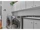 Bright laundry room featuring a washer, dryer, sink, and ample cabinet space at 867 Hanover Way, Lakeland, FL 33813