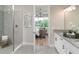 Bright bathroom featuring double sinks, white vanity, and a glass-enclosed shower at 2144 Babbling Brook Blvd, Auburndale, FL 33823