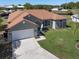 Aerial view of a well-kept single-story home with a spacious yard and a long driveway leading to a two-car garage at 1112 View Pointe Cir, Lake Wales, FL 33853