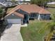 Overhead shot of a lovely one-story home featuring green lawn, a long driveway, and a two-car garage at 1112 View Pointe Cir, Lake Wales, FL 33853