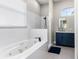 Modern bathroom with a soaking tub, a walk-in shower, and a blue vanity with ample cabinet space at 1112 View Pointe Cir, Lake Wales, FL 33853