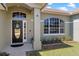 Close up on home's front door with decorative wreath, arched window, column, and landscaping at 1112 View Pointe Cir, Lake Wales, FL 33853